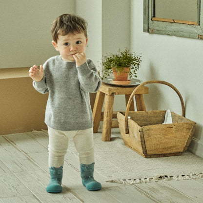 Criança a usar meias Attipas Rabbit Mint, destacando o desenvolvimento natural dos pés durante os primeiros passos.