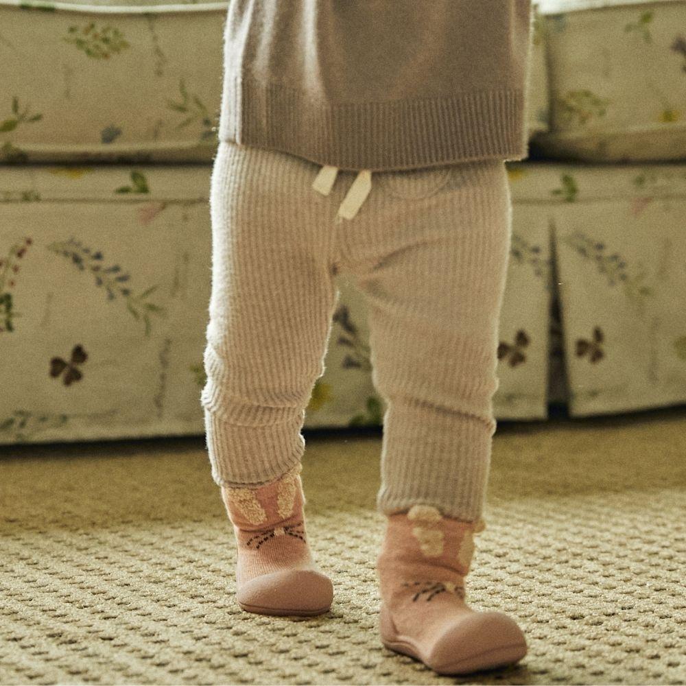 Meias Attipas Rabbit Pink em bebé, promovendo equilíbrio e liberdade de movimento ao andar.