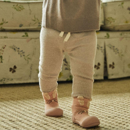 Meias Attipas Rabbit Pink em bebé, promovendo equilíbrio e liberdade de movimento ao andar.
